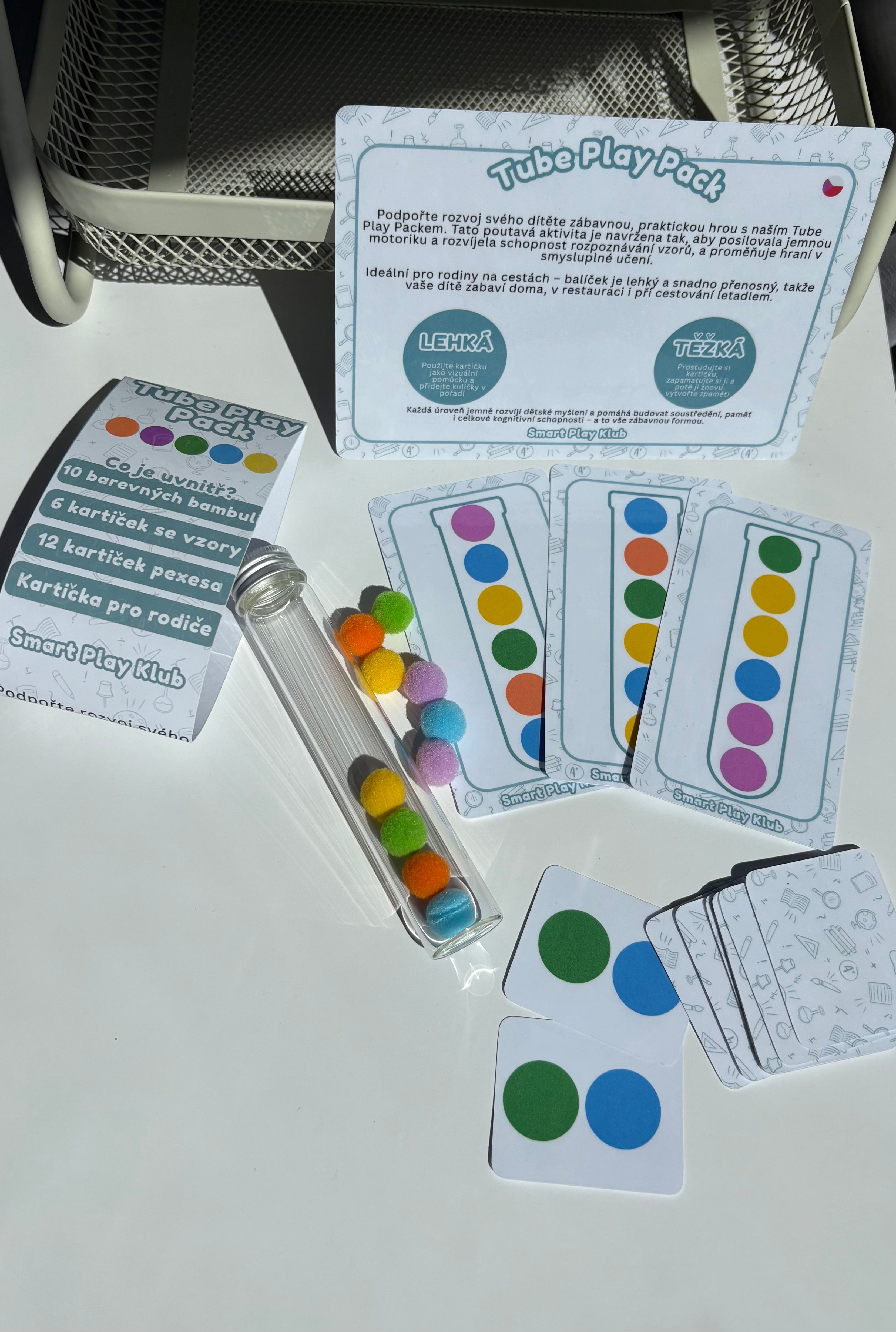 Educational materials including cards and a tube on a white surface with a chair in the background.